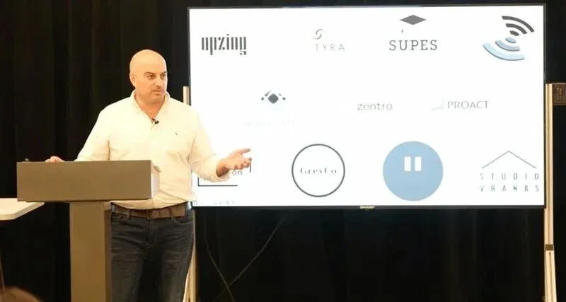 Tom Vranas on stage, talking through the operating track record